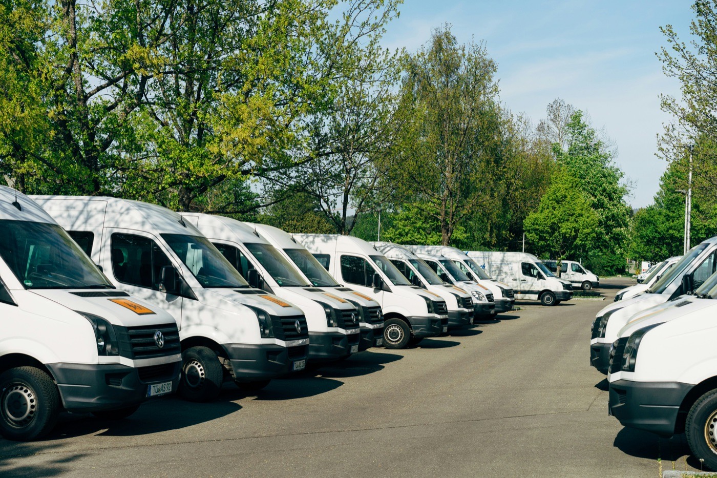 Row of white work vans parked at a depot
